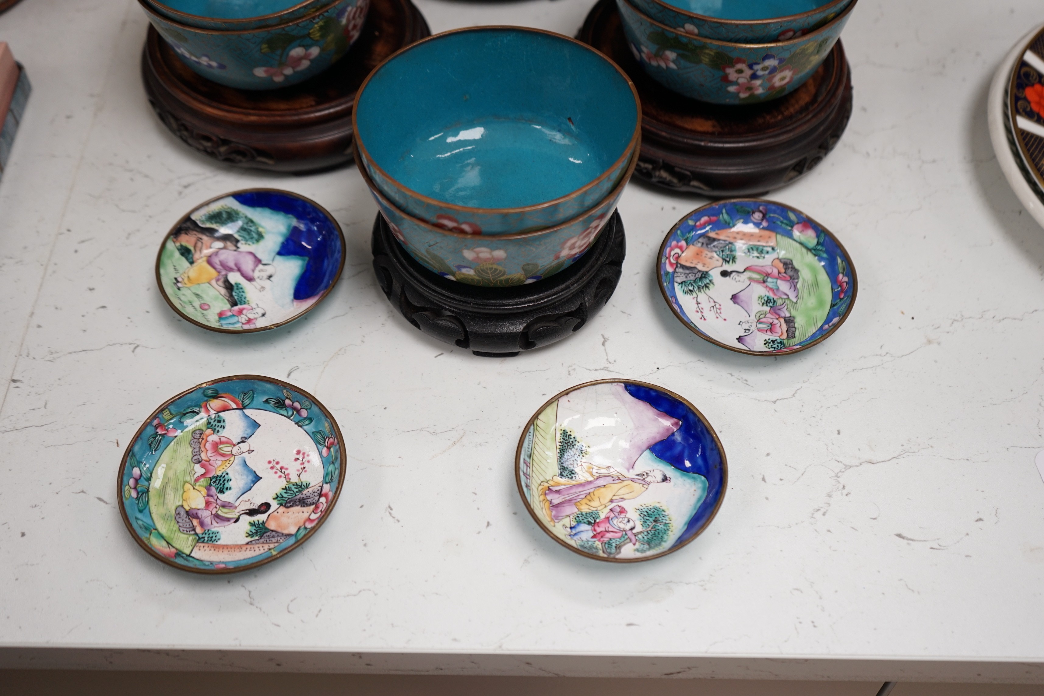 A Chinese cloisonné enamel 'dragon' bowl, six Chinese floral cloisonné enamel bowls and four Canton enamel dishes and wood stands